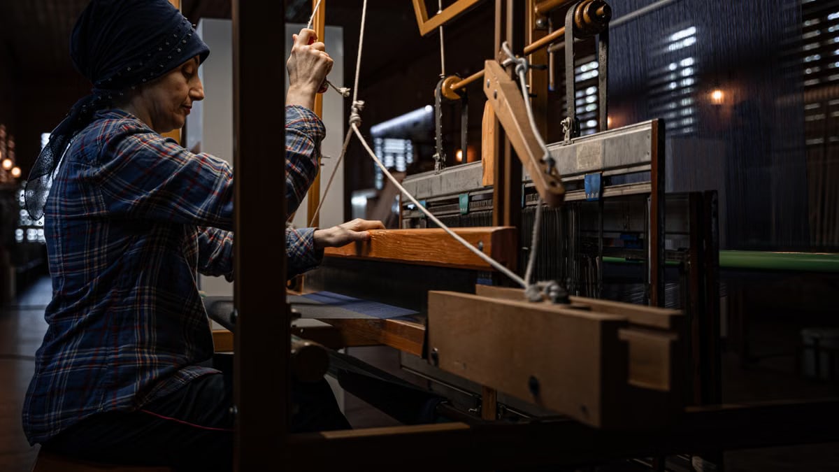 An artisan demonstrates traditional weaving techniques on a manual loom in Bursa, Türkiye.